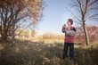 © Cavan Images - Boy with his pet dog standing in grassy field at park
