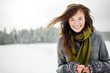 © Cavan Images - Portrait of smiling woman standing against sky in snow covered forest