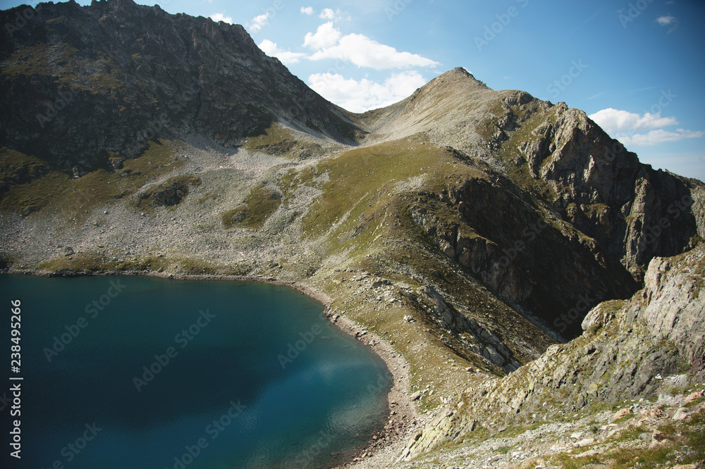 Landscape of highland lake high in the mountains of Dombai. Circus formed by a glacier with a deep lake and blue water - obrazy, fototapety, plakaty 