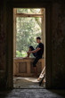 © Cavan Images - Side view of thoughtful male ballet dancer looking through window in old building