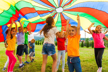 laughing boy standing hands-up outdoors in the summer