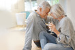 © goodluz - Romantic modern senior couple sharing glass of wine at home