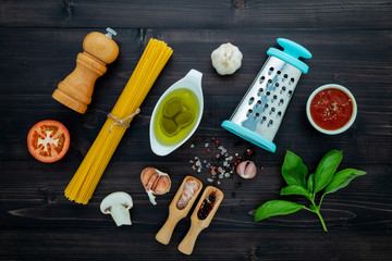 Wall Mural - The  pasta on black wooden background. Yellow italian pasta with ingredients. Italian food and menu concept.