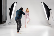 Back View Of Photographer Shooting Beautiful Young Female Model In Photo Studio