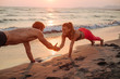 © LStockStudio - Couple Doing Pushups on Beach