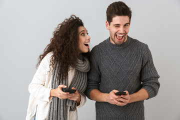 Poster - Cheerful couple wearing sweaters standing isolated