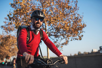 Wall Mural - Hipster businessman commuter with bicycle traveling to work in city.