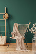 © Photographee.eu - Wicker armchair with beige blanket and wooden ladder with wicker hat, real photo with copy space on empty green wall