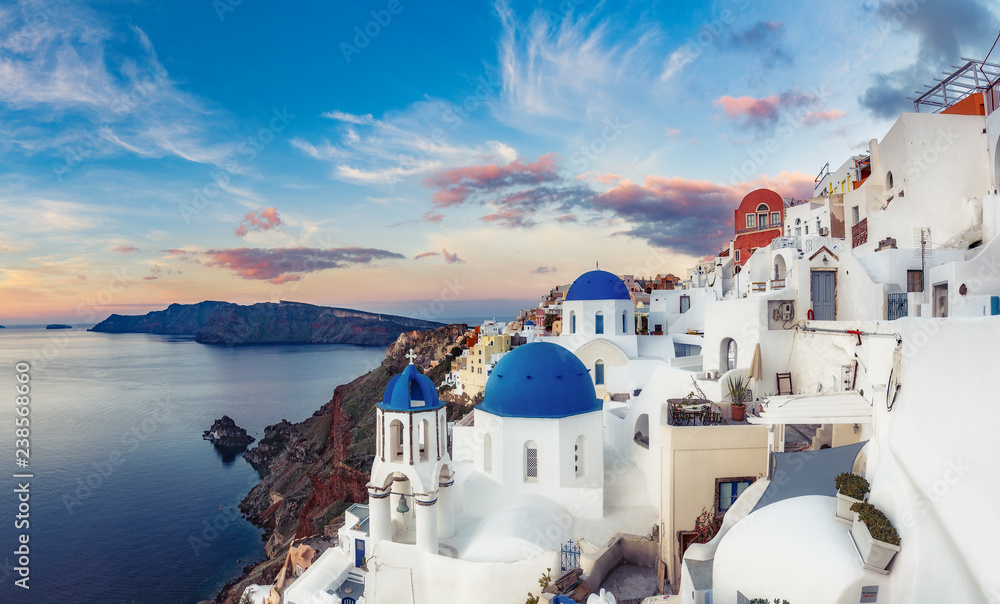 Beautiful view of Oia village on Santorini island in Greece at sunrise with dramatic sky. - obrazy, fototapety, plakaty 