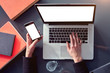 © olgapogorelova - Closeup view woman hands using mobile smartphone and laptop from above. Space for design layout mockup. Loft interior daylight.