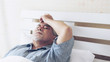 © suphaporn - Elderly patients in bed, Asian senior man patients headache hands on forehead - medical and healthcare concept