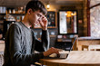 © pantovich - Stylish guy with glasses sitting in a cozy cafe for a laptop sitting online in social networks