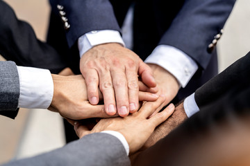 People with joined hands as a team or Teamwork business concept. view of group of Business people or Volunteer coworkers join hand together during their meeting. Horizontal. blur background