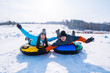 © phpetrunina14 - friends having fun. snow tubing. winter activity.