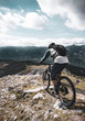 Mountain biker descending from a summit in the Alps