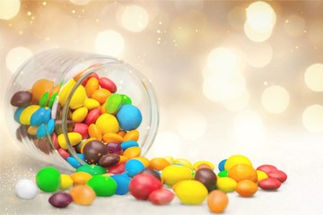 Wall Mural - Colorful candies sweets falling out of a glass jar, composition