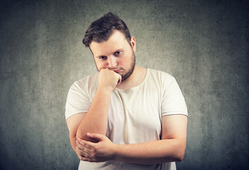 Bored gloomy fat man leaning on hand