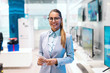 © Dusan Petkovic - Beautiful smiling Caucasian woman dressed in suit standing in tech store and looking at camera.
