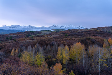 Wall Mural - Snow capped peaks rise to meet pastel sunset colored skies in the Colorado Rockies