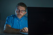 © TheVisualsYouNeed - weird tidy and neat nerd man in big glasses and shirt working happy using internet on laptop computer late night in the dark looking stupid and ridiculous isolated background