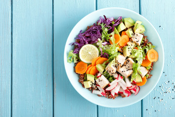 Wall Mural - Bowl with grilled chicken meat, brown rice and fresh vegetable salad of avocado, radish, cabbage kale, carrot, and lettuce leaves. Healthy and delicious dietary lunch. Top view