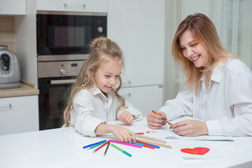 Mother and daughter are drawing together at home