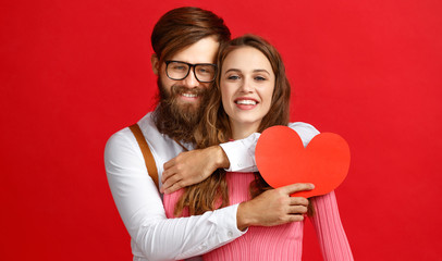 Wall Mural - valentine's day concept. happy young couple with heart, flowers, gift on red