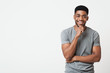 © Prostock-studio - Interested smiling african-american man touching chin, copy space
