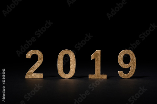 Fotografía Año nuevo en números de madera 2019, color dorado sobre fondo negro