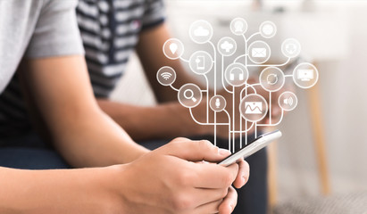 Young man using smartphone with virtual icons