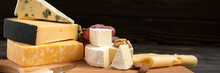 Various Types Of Cheese On A Rustic Table