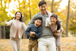 © Blue Jean Images - Happy young family playing in autumn woods