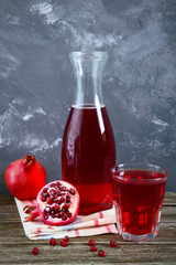 Wall Mural - Ripe pomegranate fruit, bottle and glass of fresh pomegranate juice on wooden table. Healthy eating concept.