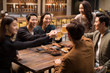 © Blue Jean Images - Happy friends toasting and talking in bar