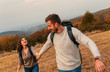 © Zoran Zeremski - Young couple enjoying hiking in nature They are holding hands and laughing.