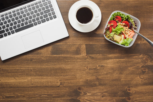 Healthy business lunch in office, salad, coffee on wooden table. Top view with copy space. Concept healthy nutrition. Lunchbox.