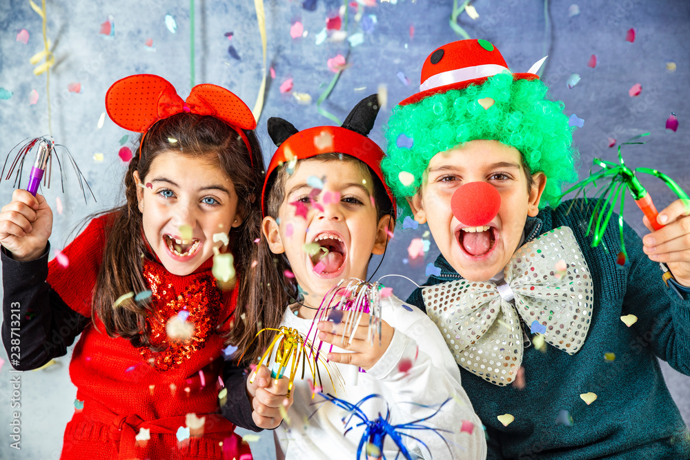 Three kids celebrating Carnival  together at home - obrazy, fototapety, plakaty 