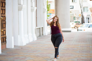 Pretty young woman walking on the city street. Casual fashion, plus size model. xxl women on nature.