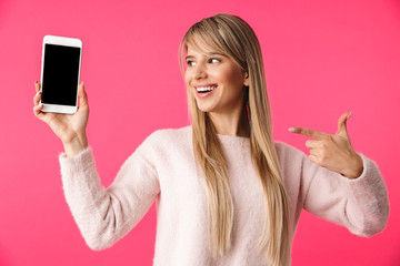 Wall Mural - Cheerful young blonde woman wearing sweater