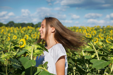 Poster - Young girl dances in a field of sunflowers.