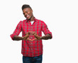 © Krakenimages.com - Young african american man over isolated background smiling in love showing heart symbol and shape with hands. Romantic concept.