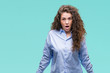 © Krakenimages.com - Beautiful brunette curly hair young girl wearing elgant look over isolated background afraid and shocked with surprise expression, fear and excited face.