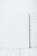 © LIGHTFIELD STUDIOS - blank placard on white wooden table near brick wall