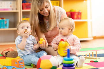  opiekunka do dziecka i dzieci bawiące się razem w pokoju dziecinnym lub w domu