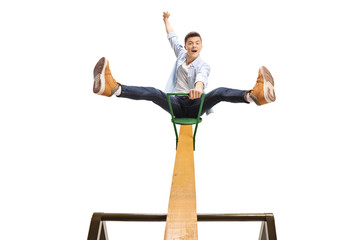 Poster - Energetic teenage boy sitting on a seesaw