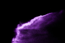 Purple Sand Explosion Isolated On Black Background. Abstract Sand Cloud.Purple Sand Splash Against  On Dark Background.