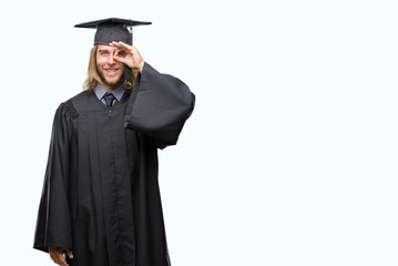 Poster - Young handsome graduated man with long hair over isolated background doing ok gesture with hand smiling, eye looking through fingers with happy face.