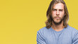 © Krakenimages.com - Young handsome man with long hair over isolated background skeptic and nervous, disapproving expression on face with crossed arms. Negative person.