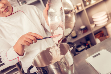 Wall Mural - Serious nice pastry chef looking into the bowl