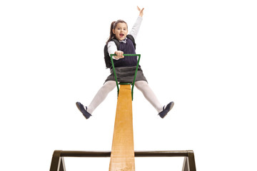 Canvas Print - Joyful little schoolgirl on a seesaw holding her hand up